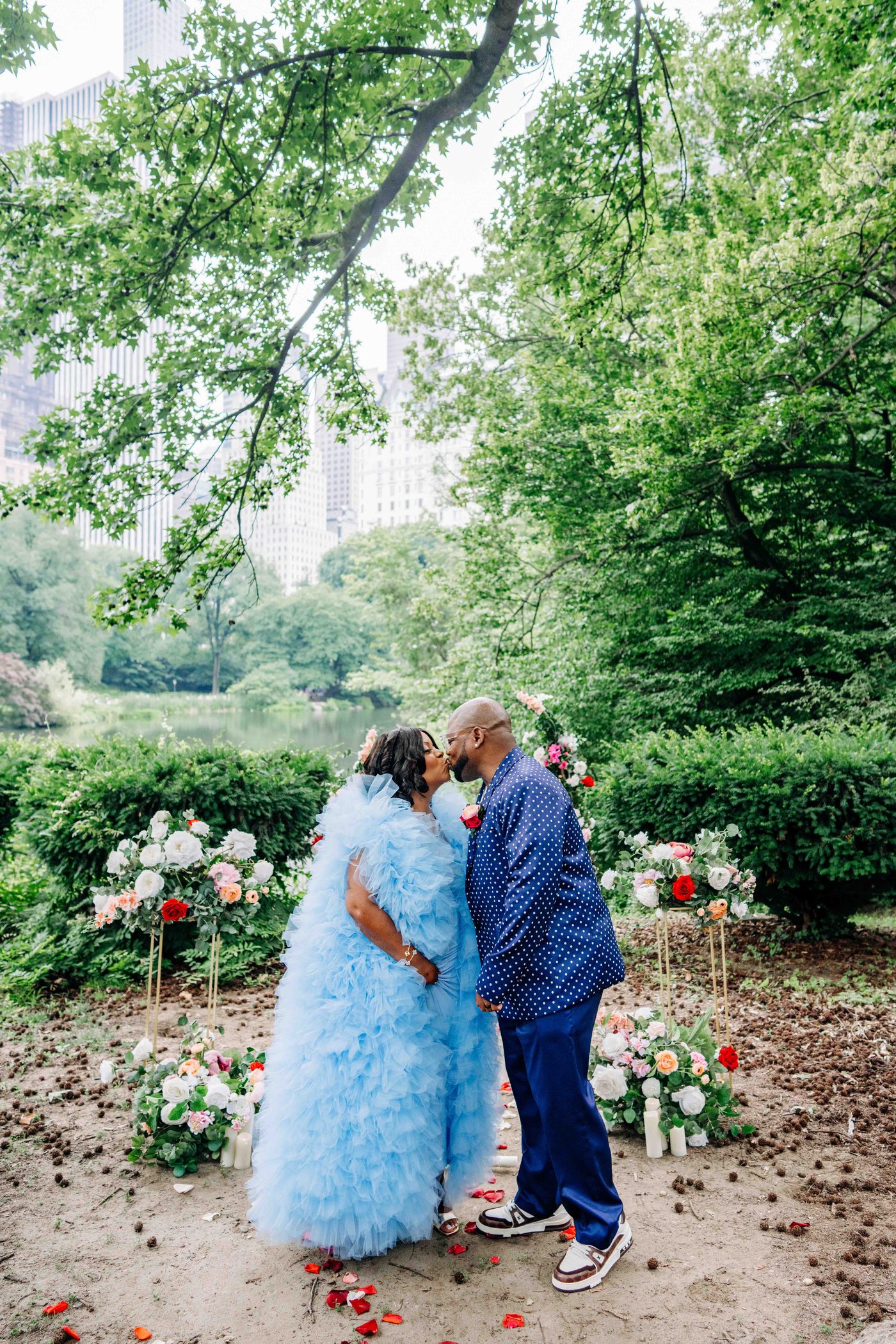 Bold floral installation, couple embrace, vivid color edit